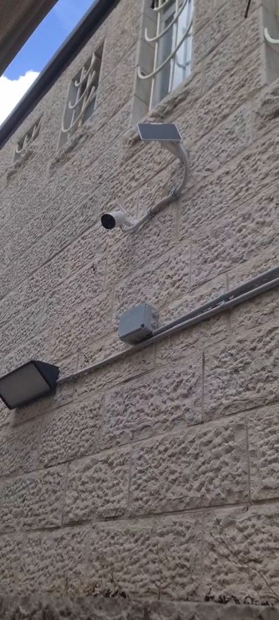 מצלמה ופאנל סולארי על קיר אבן